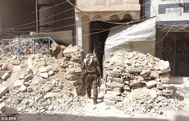 Entry: ISIS media claimed last week that five Russian special forces officers had been killed near Palmyra (pictured, a Syrian soldier in the ancient city)