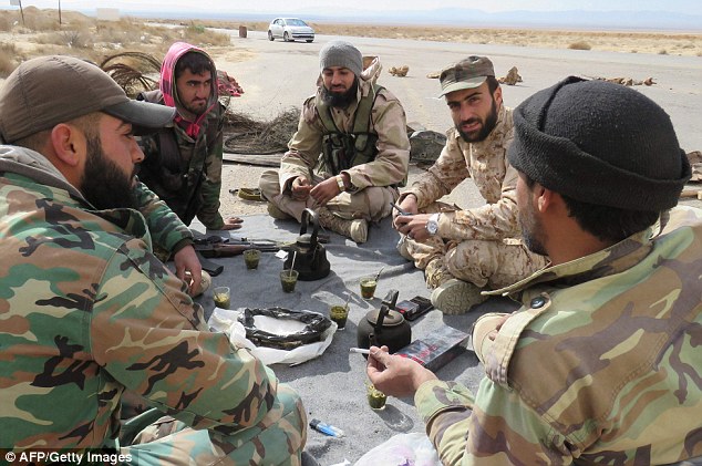 Victory: Syrian soldiers (pictured) rest at a neighbourhood in the historical city of Palmyra which was recently liberated from ISIS control
